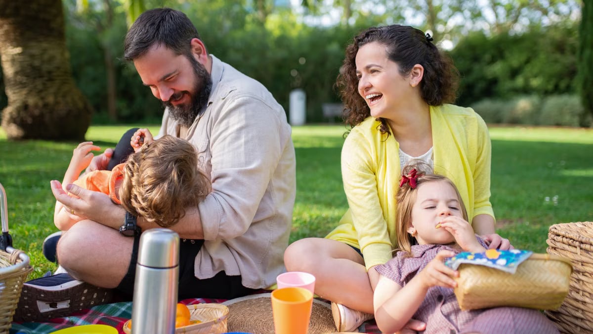Happy family having a picnic on a sunny day in a park, enjoying togetherness and relaxation.